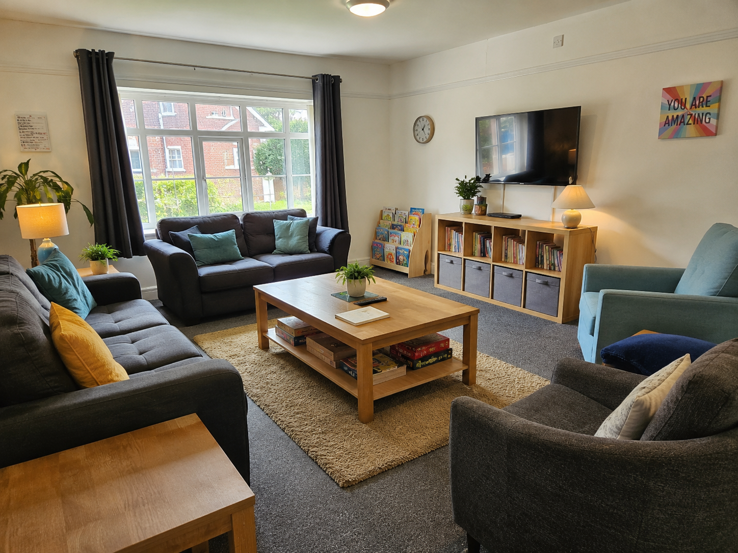 Warm care home lounge with sofas, books and soft furnishings